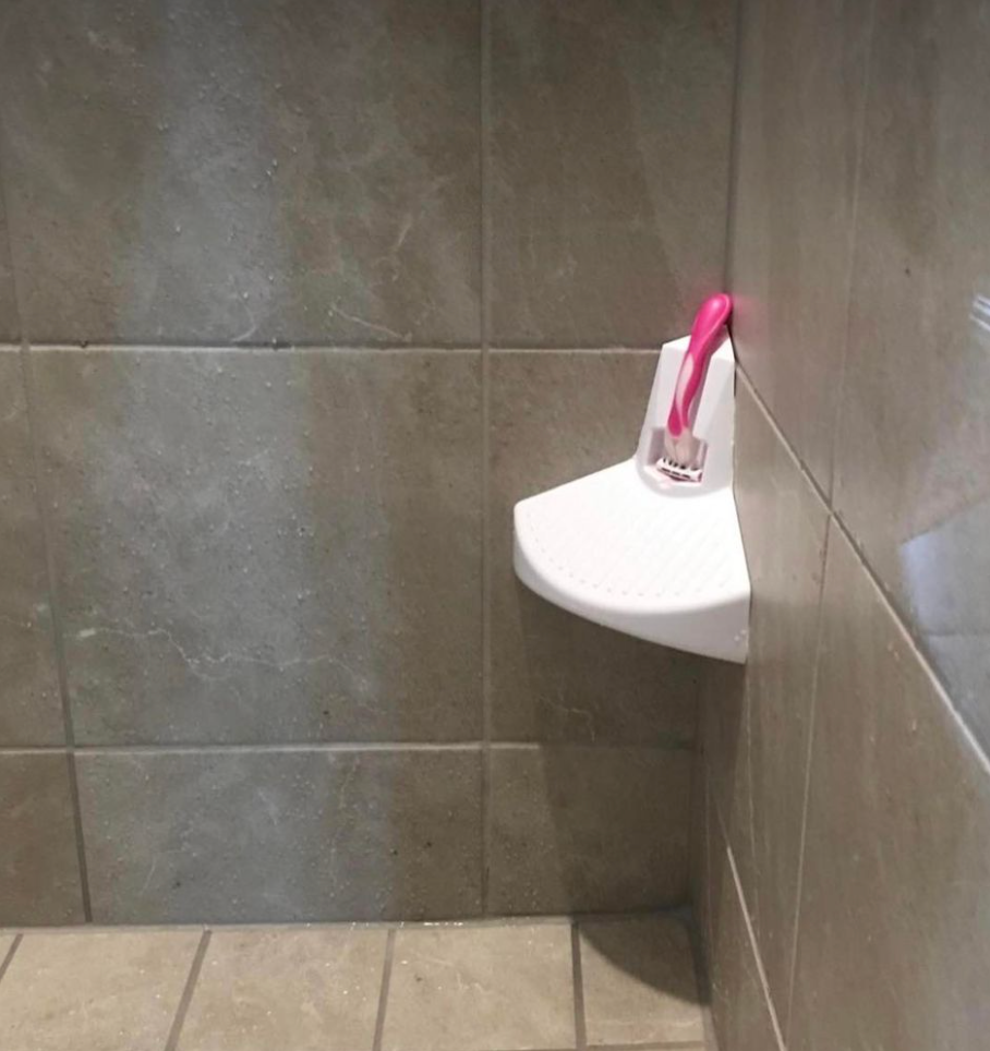 shower step installed on dark shower tiles